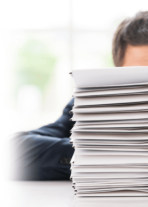 employee behind stack of papers